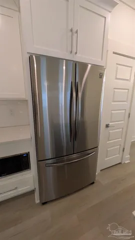 a metallic refrigerator freezer sitting in a kitchen