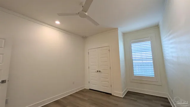 an empty room with wooden floor and window