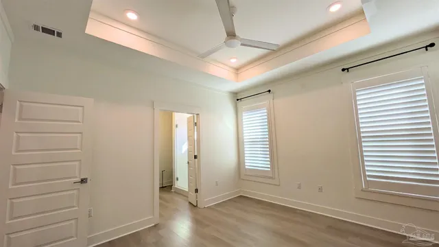 an empty room with wooden floor and windows