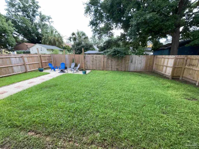 a view of backyard with small cabin and wooden fence