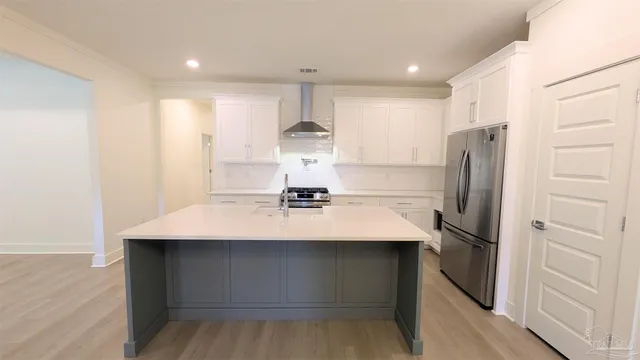 a kitchen with kitchen island white cabinets and stainless steel appliances