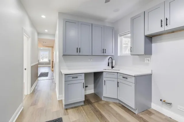 a kitchen with white cabinets and sink