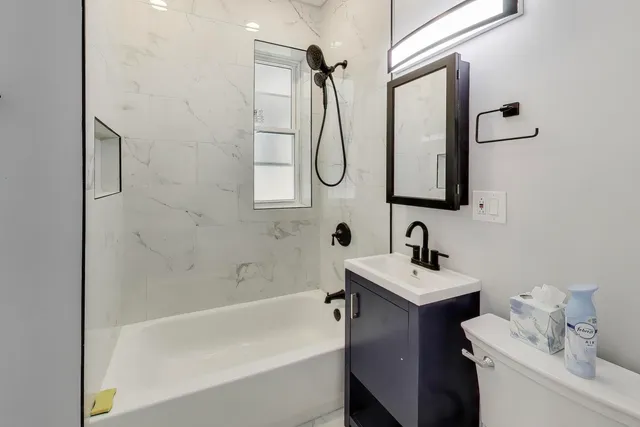 a bathroom with a sink vanity mirror and toilet