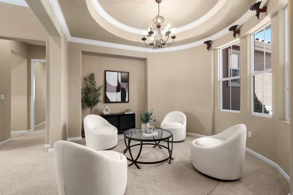 a living room with furniture a chandelier and a rug