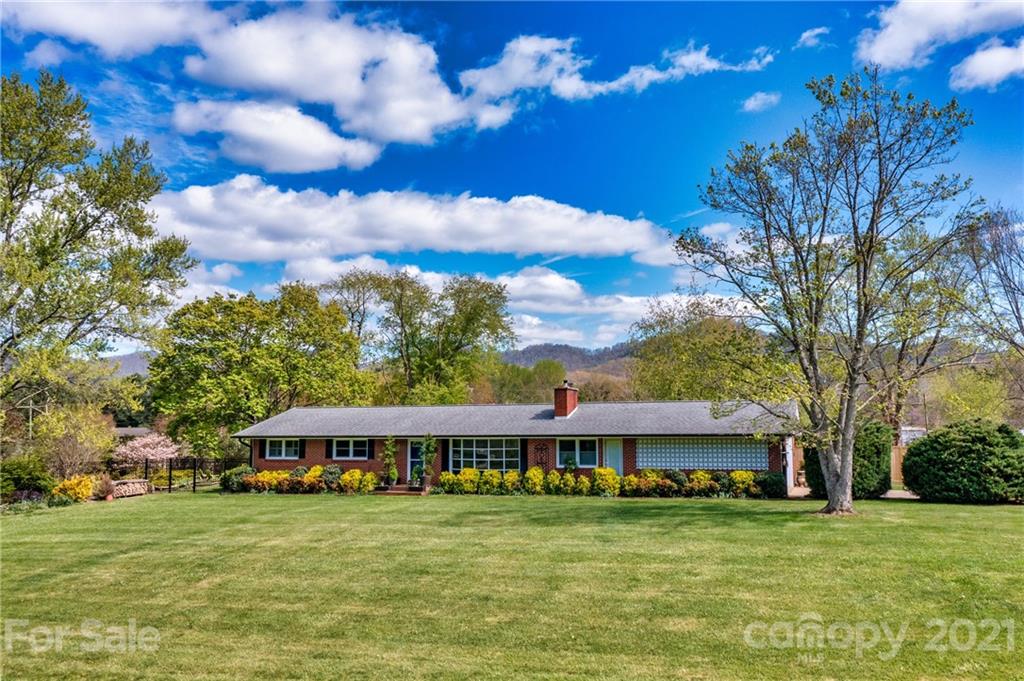 208 Wells Road Canton, NC 28716 - Photo 1 of 35 a front view of a house with a garden