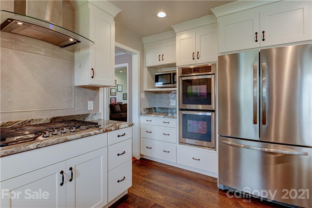 208 Wells Road Canton, NC 28716 - Photo 16 of 35 a kitchen with stainless steel appliances a refrigerator a stove and white cabinets