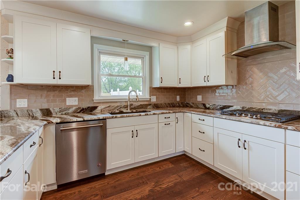 208 Wells Road Canton, NC 28716 - Photo 17 of 35 a kitchen with stainless steel appliances granite countertop a stove a sink and white cabinets