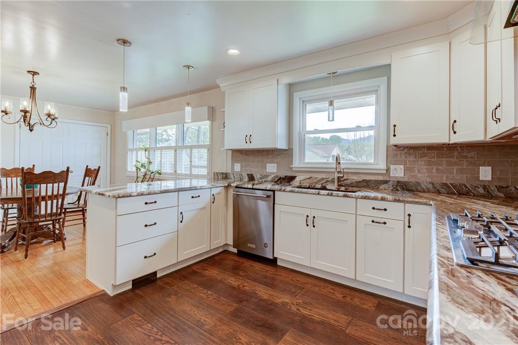 208 Wells Road Canton, NC 28716 - Photo 19 of 35 a kitchen with granite countertop white cabinets white appliances with wooden floors