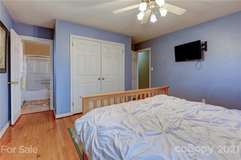 208 Wells Road Canton, NC 28716 - Photo 28 of 35 a bedroom with a bed and a flat tv screen on dresser