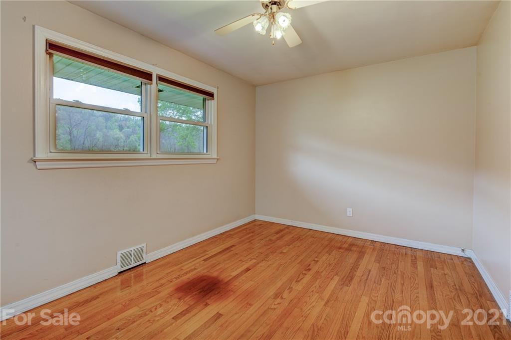208 Wells Road Canton, NC 28716 - Photo 30 of 35 an empty room with wooden floor and windows