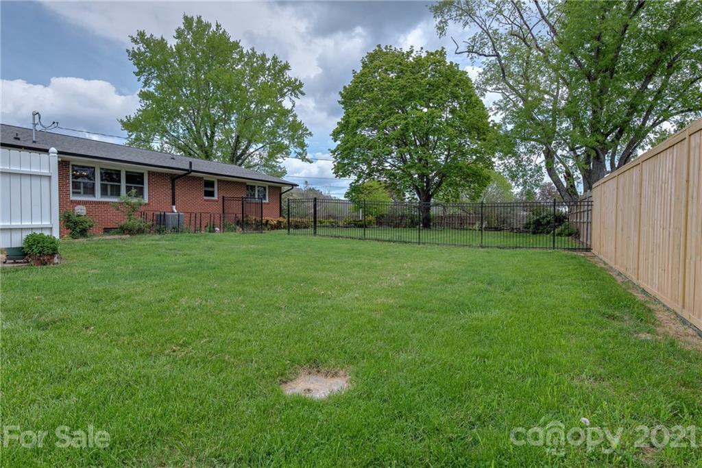 208 Wells Road Canton, NC 28716 - Photo 33 of 35 a view of a backyard with table and chairs and a large tree