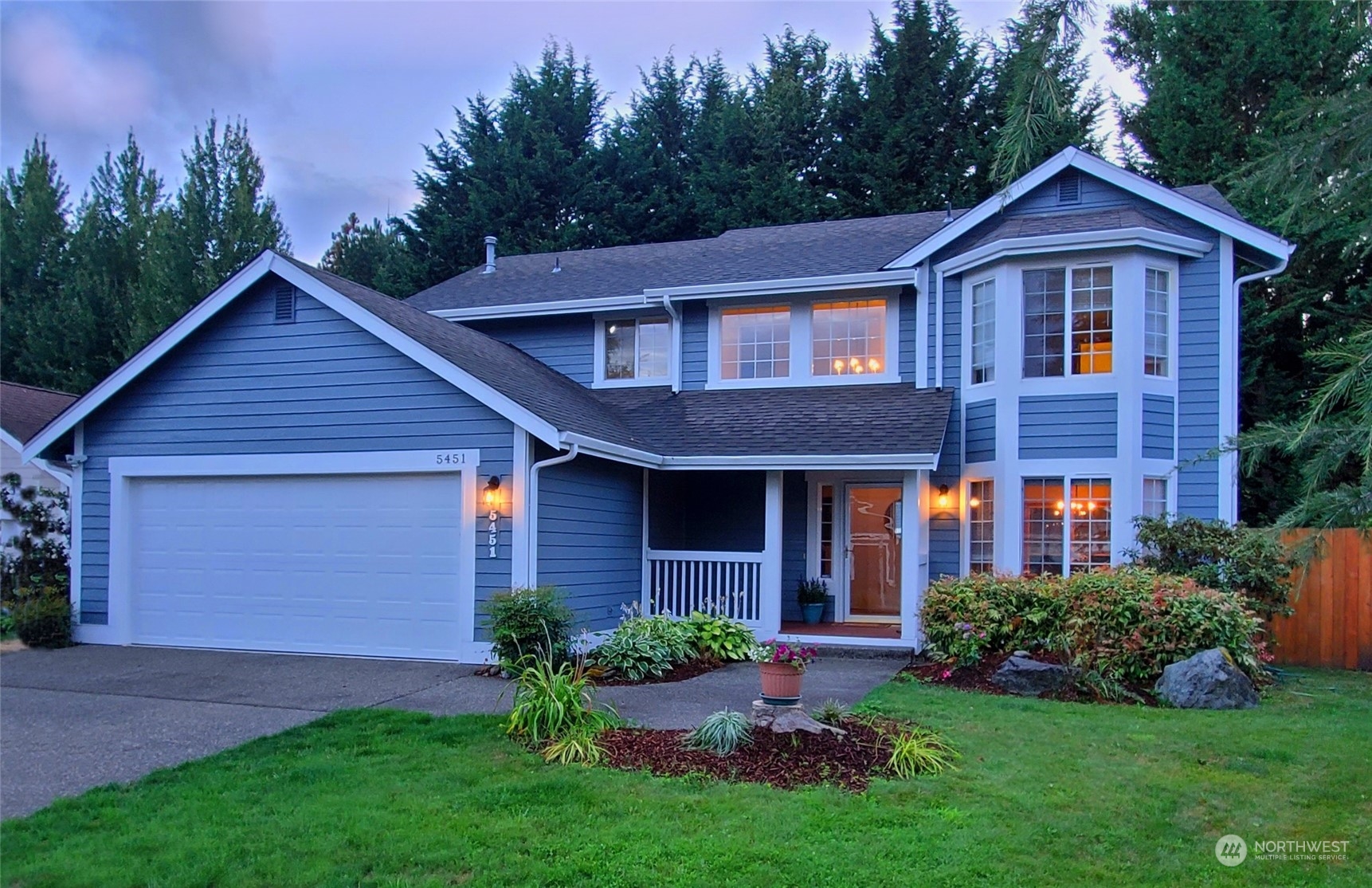a front view of a house with a garden and plants