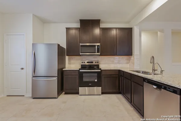 a kitchen with granite countertop stainless steel appliances and refrigerator