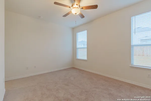 an empty room with a window and a fan