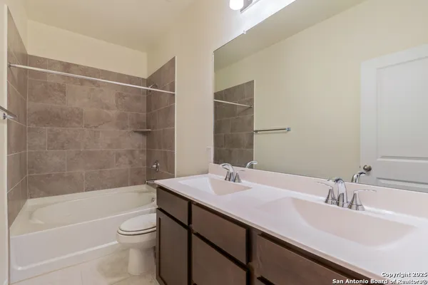 a bathroom with a granite countertop sink a toilet and bathtub