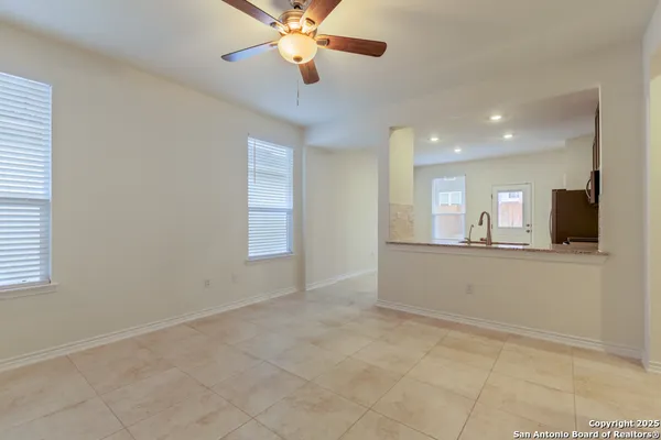 a view of an empty room and a kitchen