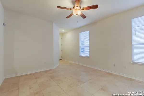 an empty room with windows and fan