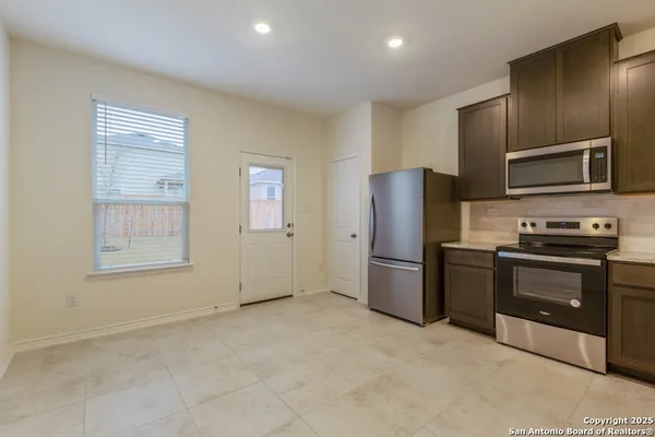 a kitchen with a refrigerator sink and stove top oven