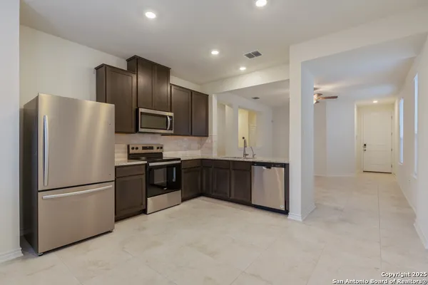 a kitchen with granite countertop stainless steel appliances a refrigerator and a refrigerator