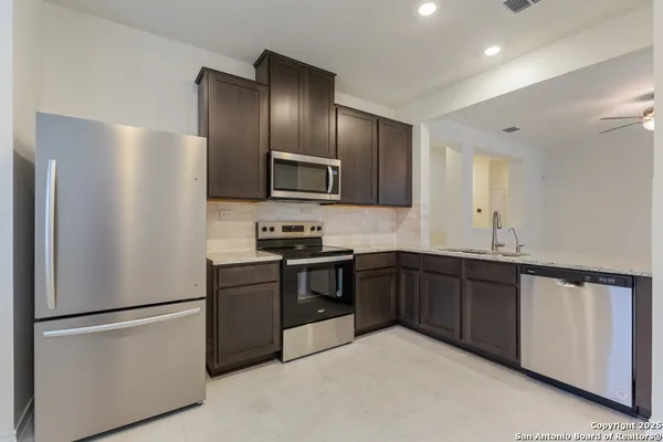 a kitchen with granite countertop stainless steel appliances and refrigerator