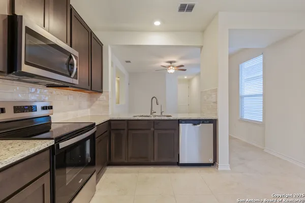 a kitchen with stainless steel appliances granite countertop a sink and stove top oven