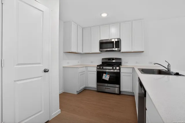 a kitchen with a refrigerator and a stove top oven