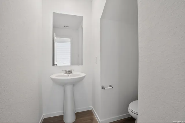 a bathroom with a sink mirror and toilet