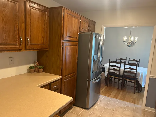 a kitchen with refrigerator and chairs