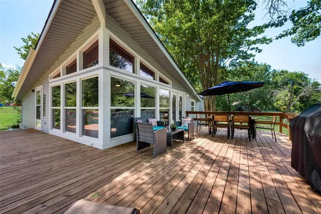 a view of a house with wooden deck and furniture