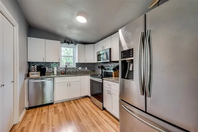 a kitchen with stainless steel appliances a refrigerator sink and microwave