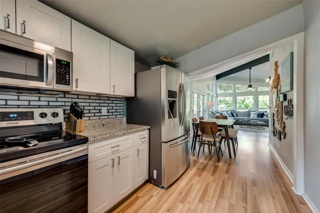 a kitchen with a stove a refrigerator and wooden floor