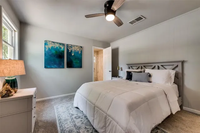 a bedroom with a bed and a lamp on dresser