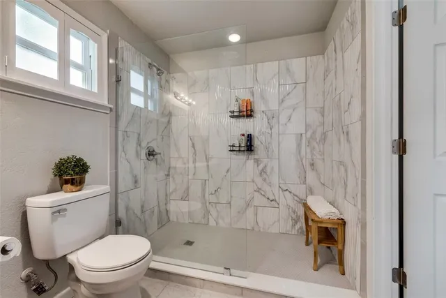 a white toilet sitting next to a bath tub shower