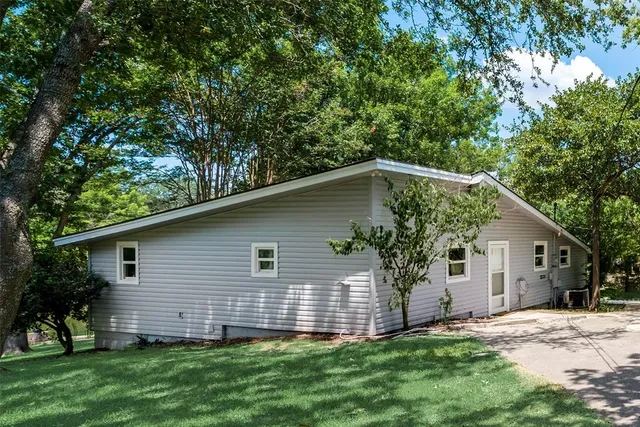 a house that has a tree in front of a white house