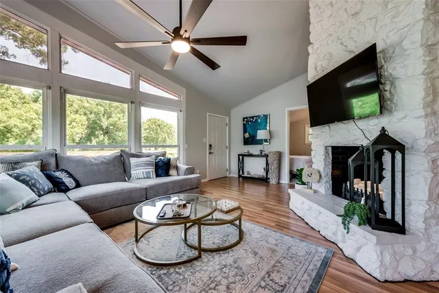 a living room with furniture a flat screen tv and a fireplace