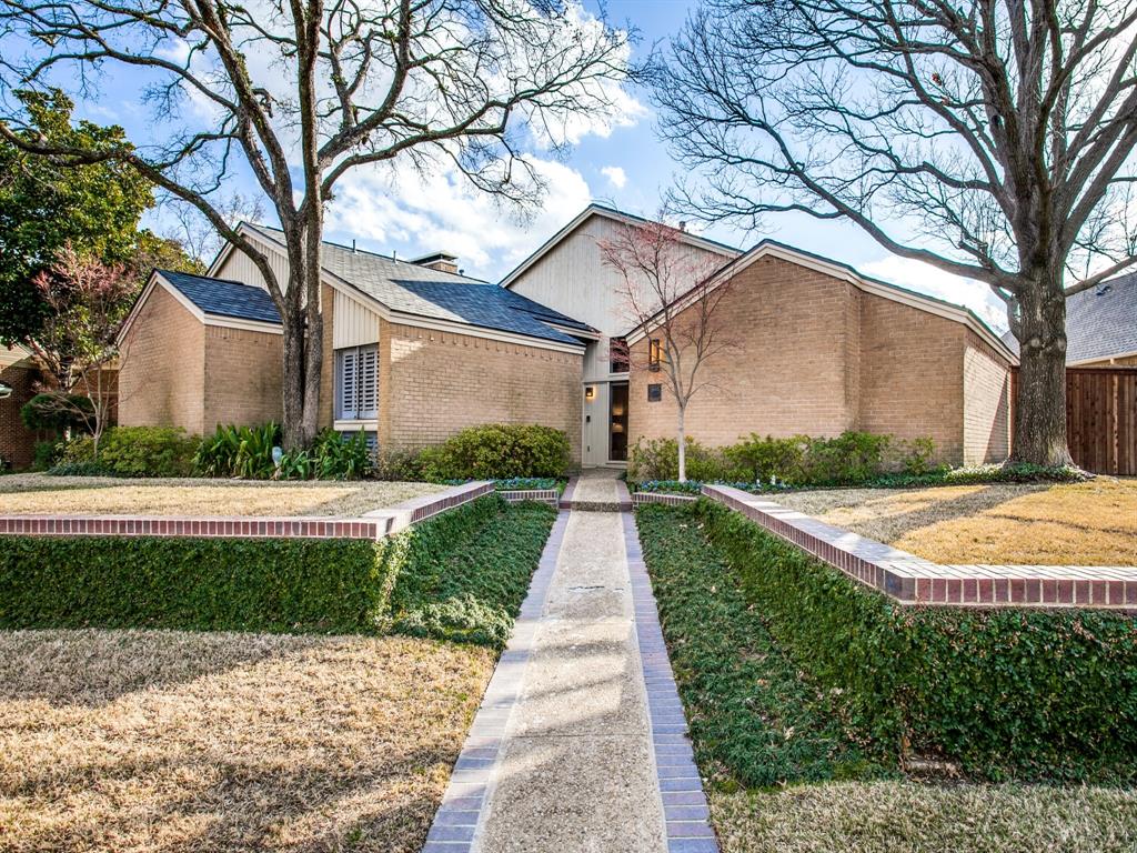 a front view of a house with yard and green space
