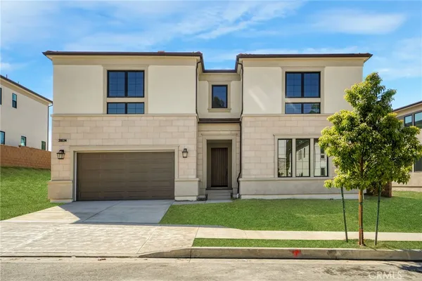 a front view of a house with a garden and garage