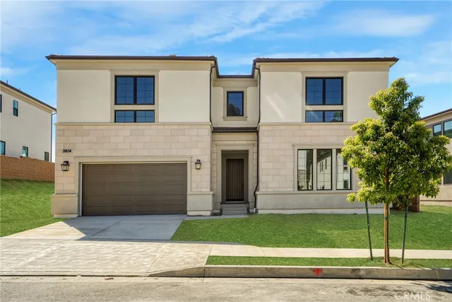 a front view of a house with a garden and garage