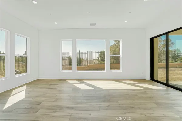 a view of a kitchen with kitchen island stainless steel appliances wooden floors and view living room