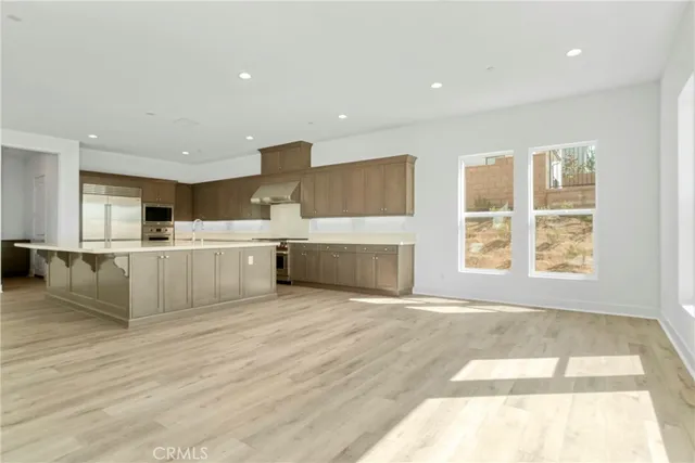 a large white kitchen with wooden floors and a fireplace