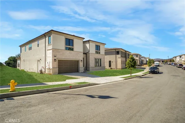 a view of a white house with a big yard and large trees