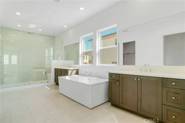 a spacious bathroom with a tub sink and mirror