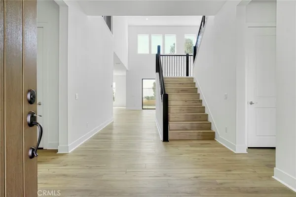 a view of a hallway with wooden floor and staircase