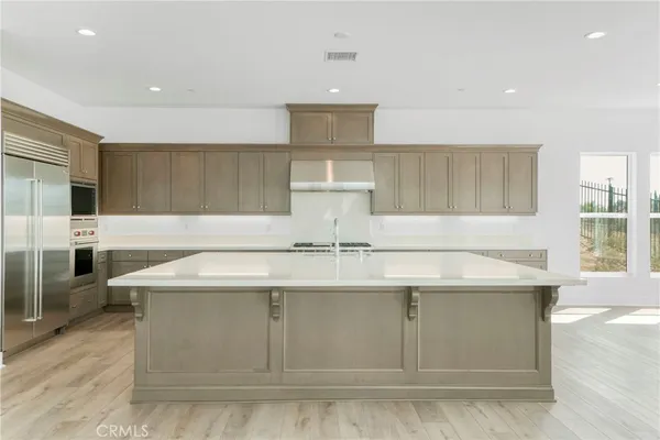 a kitchen with stainless steel appliances granite countertop a sink a stove and a refrigerator