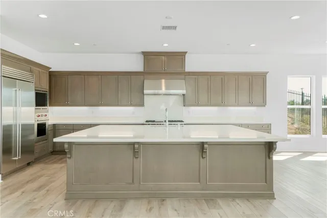 a kitchen with stainless steel appliances granite countertop a sink a stove and a refrigerator