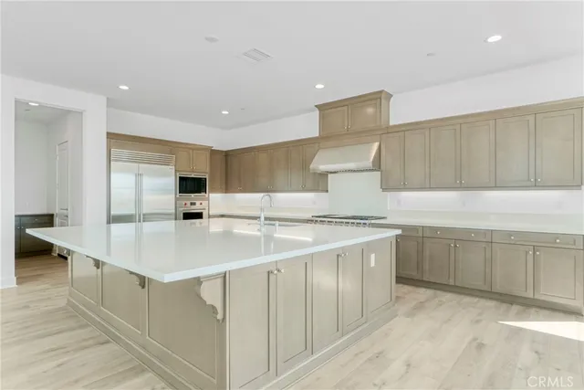 a large white kitchen with cabinets