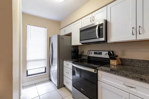 a kitchen with stainless steel appliances granite countertop a refrigerator and a stove
