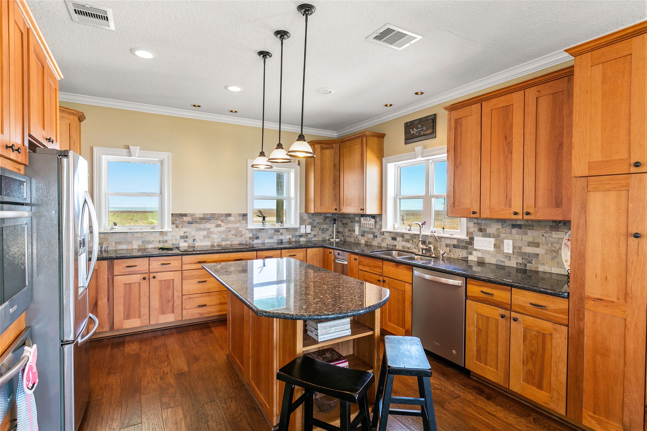 10530 Bluewater Highway Freeport, TX 77541 - Photo 17 of 43 a kitchen with stainless steel appliances granite countertop a sink a stove and a wooden floors