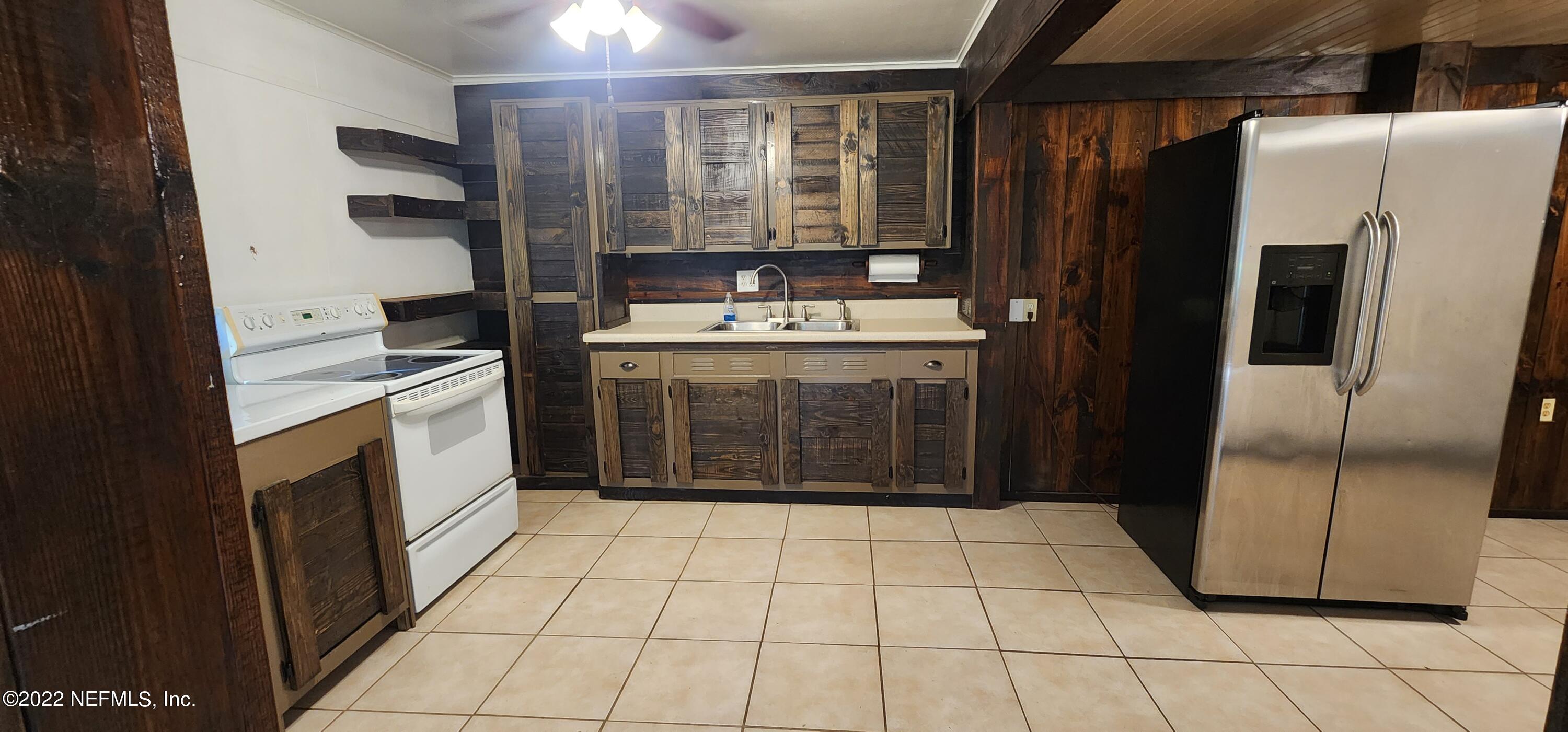 25035 Northeast 131st Place Salt Springs, FL 32134 - Photo 16 of 21 a kitchen with a refrigerator sink and cabinets