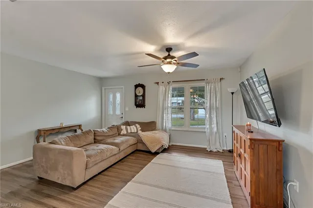 a living room with furniture a flat screen tv and a window